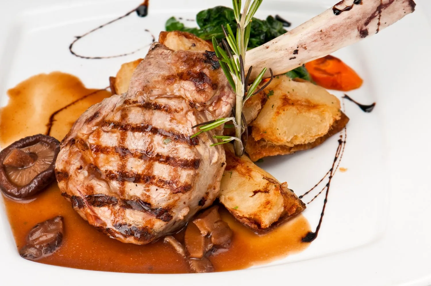 Grillet kotelet anrettet med tilbehør og sauce